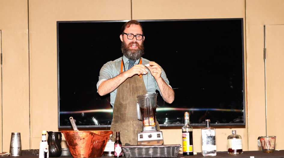 man showing how to make mixed whiskey drinks
